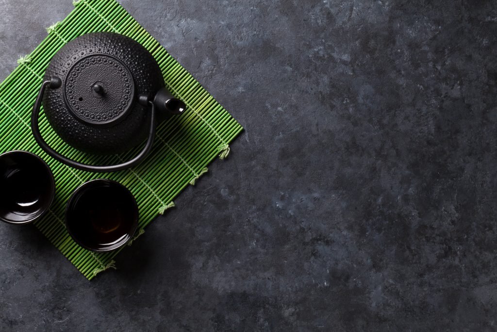 Black Iron Teapot On Bamboo Mat